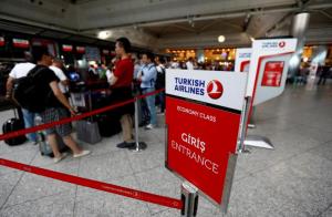 FILE PHOTO: Passengers wait in line at a Turkish Airlines counter at the international departure terminal of the Ataturk airport in Istanbul